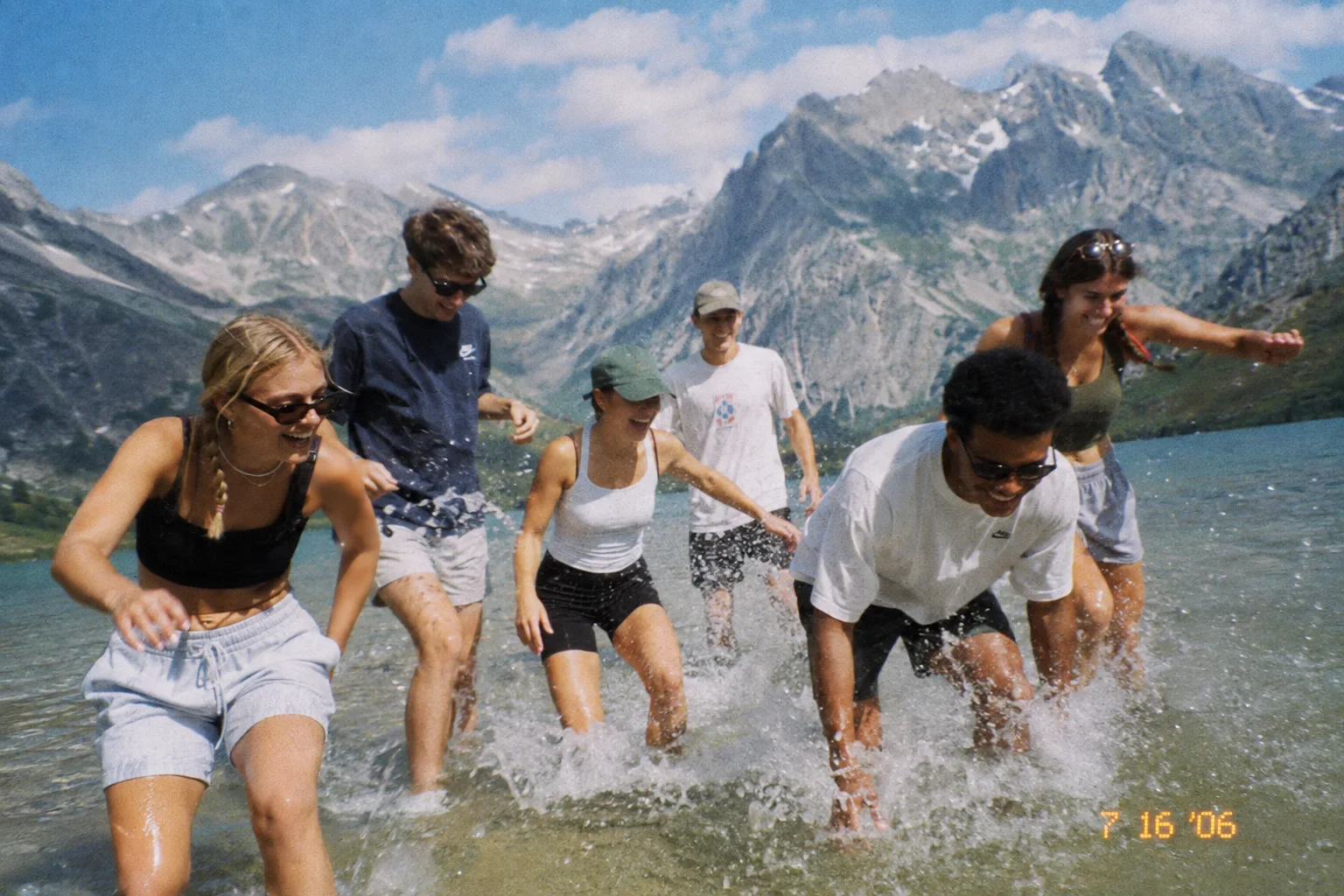 Friends running into an alpine lake
